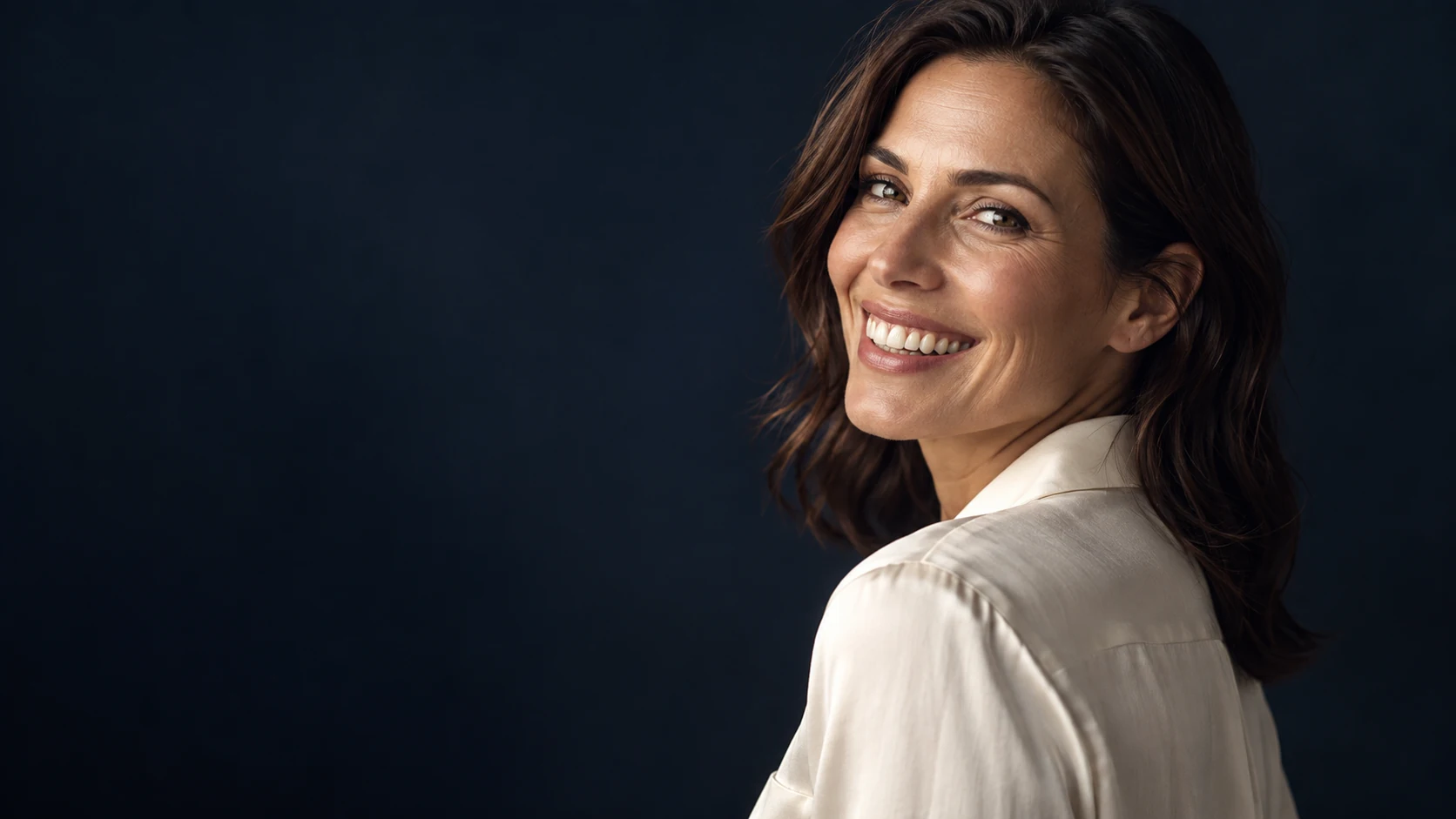 A woman sharing a relaxed smile in warm light; illustrative portrait
